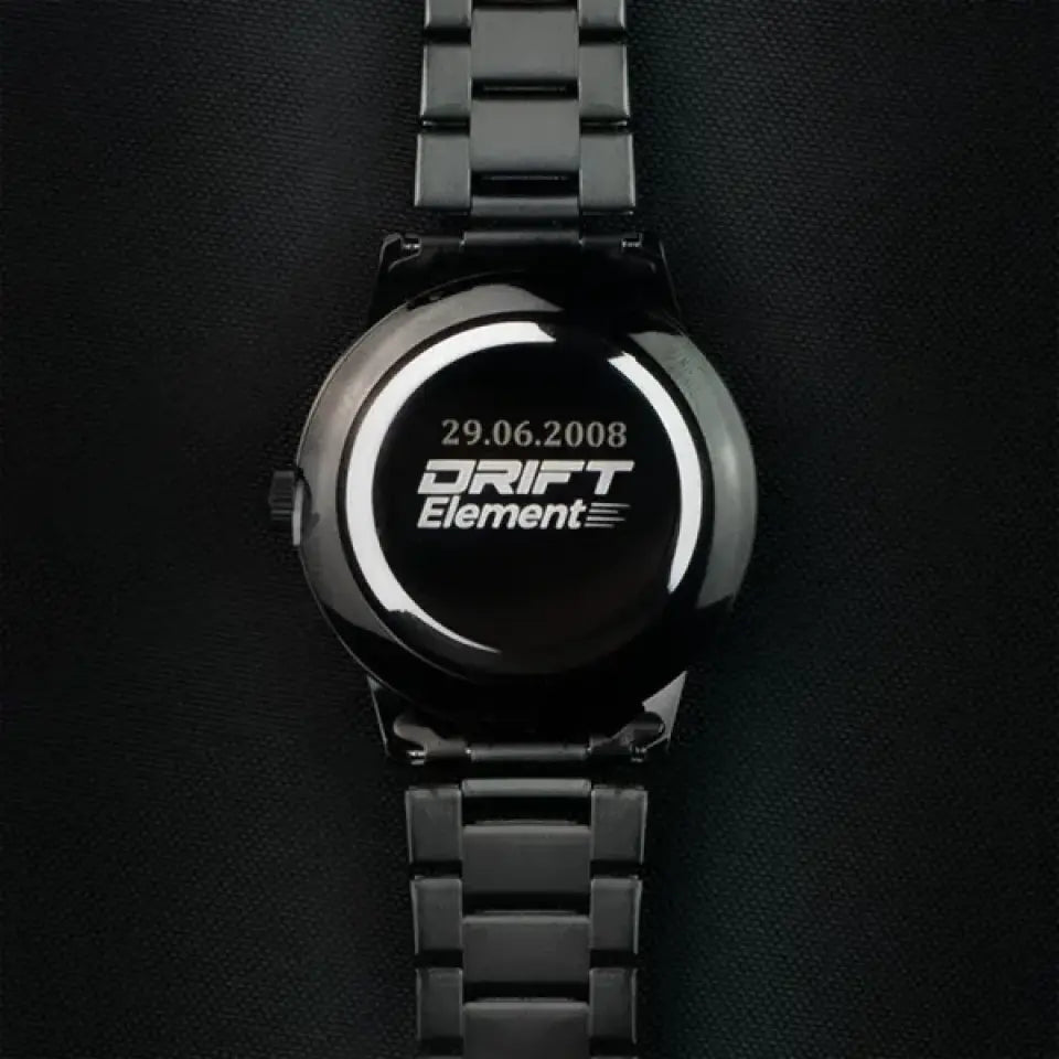 A sleek black watch from DriftElement with a custom engraving on the back showcasing the date '29.06.2008' above the brand's logo. The image highlights the personalized aspect of the innovative wheel-inspired watch design, typical of the creative and modern approach of the young German startup.