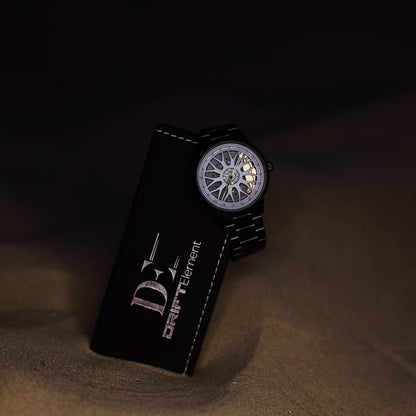 A DriftElement Final Edition watch leaning on its branded packaging, displaying a sophisticated grey rim design on the dial. This innovative watch from the young German startup blends the essence of automotive design with the precision of modern watchmaking.