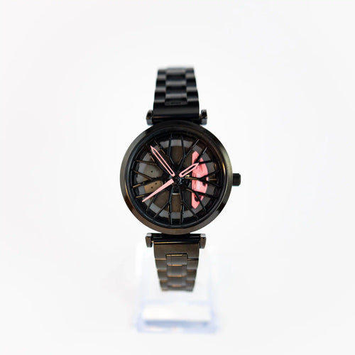 This image features the DriftElement Lady Like Edition, a women's wristwatch that elegantly combines motorsport aesthetics with feminine touches. The watch boasts a sleek, black metal band and body. The face of the watch is inspired by a car's rim, with a detailed, wheel-like design and eye-catching pink highlights on the hands and hour markers, adding a pop of color and style. This innovative design is emblematic of DriftElement, a young German startup that specializes in rim-design watches.