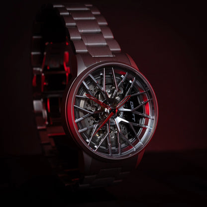 An image featuring the Automatic Motorsport EMS Edition watch by DriftElement, characterized by its distinctive rim design and red accents. This innovative timepiece reflects the fusion of automotive inspiration and precision engineering emblematic of the young German startup. The watch showcases a dynamic aesthetic, appealing to enthusiasts of both motorsports and horology.